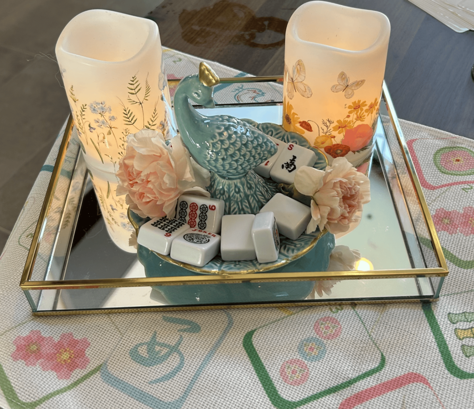 Candlelit centerpiece with peacock, florals, and mahjong tiles