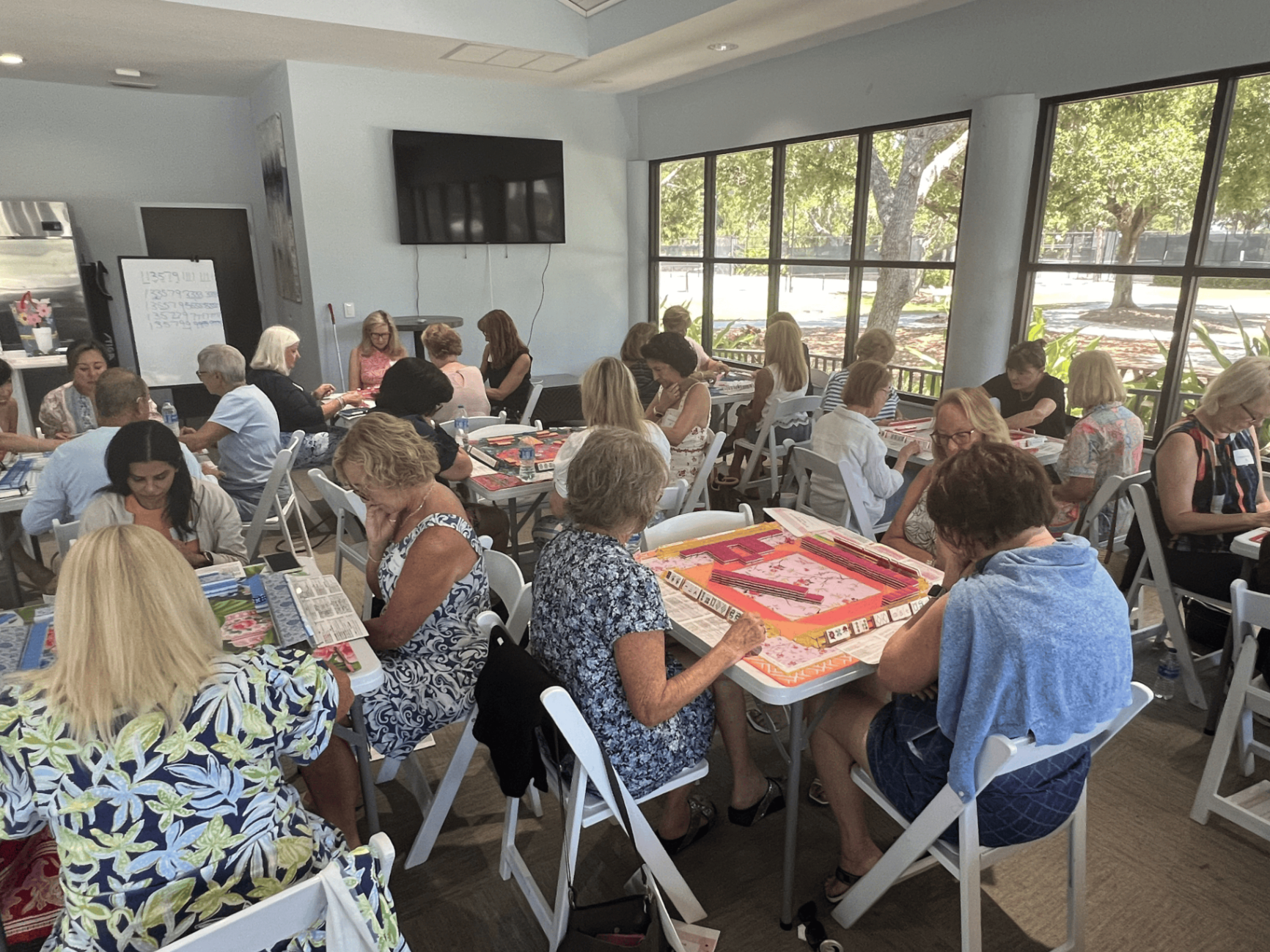 Multiple mahjong tables in a bright social room